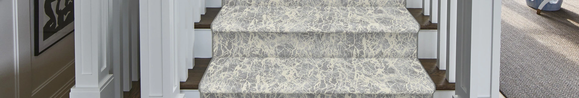 cream and blue stair runner on wooden stairs